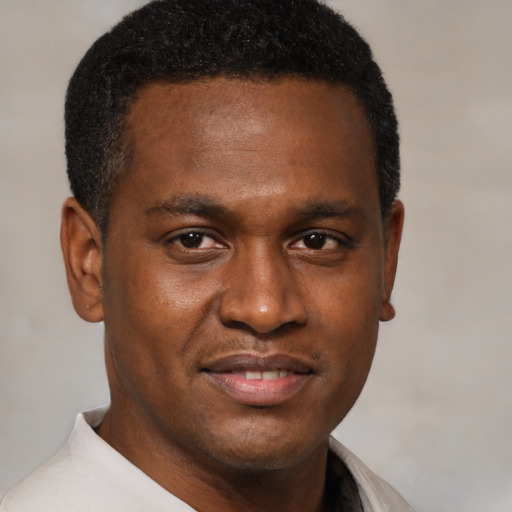 Joyful black young-adult male with short  brown hair and brown eyes