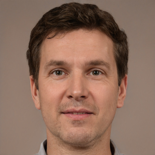 Joyful white adult male with short  brown hair and brown eyes