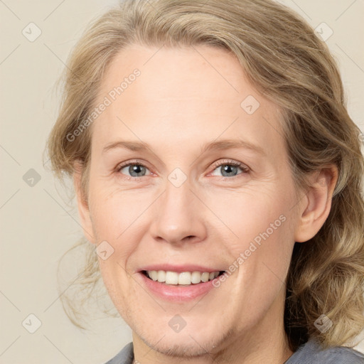 Joyful white adult female with medium  brown hair and blue eyes