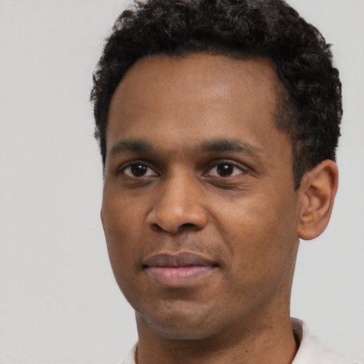 Joyful black young-adult male with short  black hair and brown eyes