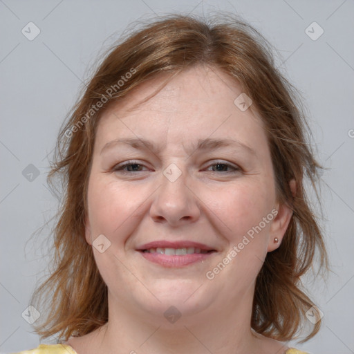 Joyful white adult female with medium  brown hair and blue eyes