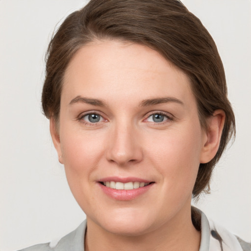 Joyful white young-adult female with short  brown hair and grey eyes