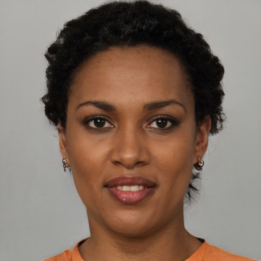 Joyful black young-adult female with short  black hair and brown eyes