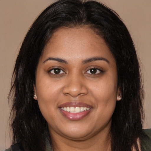 Joyful black young-adult female with long  brown hair and brown eyes