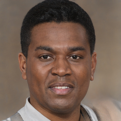 Joyful black young-adult male with short  black hair and brown eyes