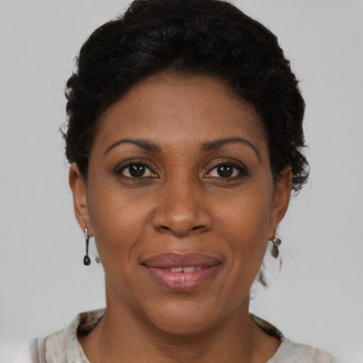 Joyful black young-adult female with short  brown hair and brown eyes
