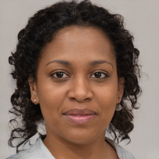 Joyful black young-adult female with medium  brown hair and brown eyes