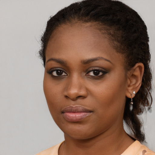 Joyful black young-adult female with medium  brown hair and brown eyes