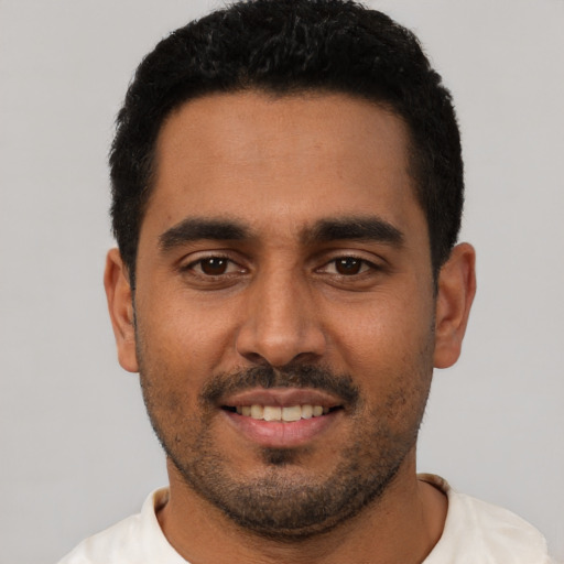 Joyful black young-adult male with short  black hair and brown eyes