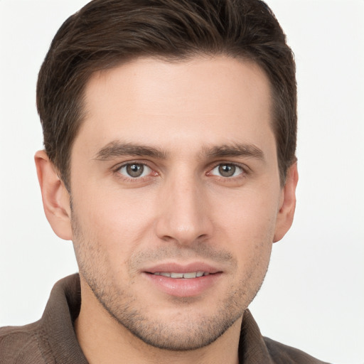 Joyful white young-adult male with short  brown hair and grey eyes