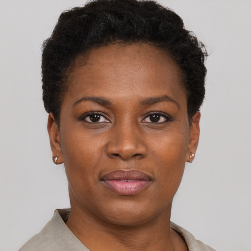 Joyful black young-adult female with short  brown hair and brown eyes