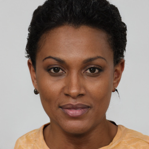 Joyful black young-adult female with short  black hair and brown eyes