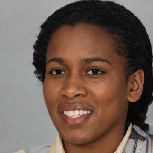 Joyful black young-adult female with short  black hair and brown eyes