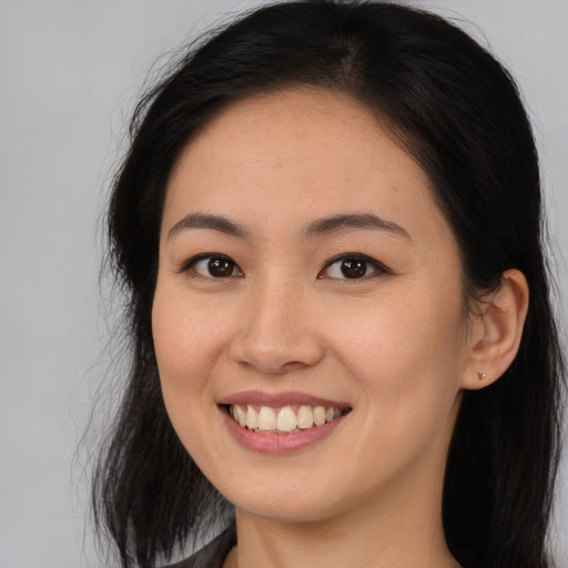 Joyful asian young-adult female with long  brown hair and brown eyes