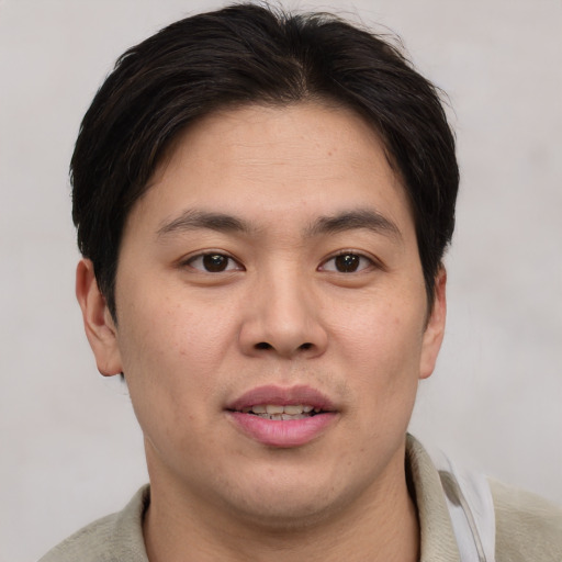 Joyful asian young-adult male with short  brown hair and brown eyes