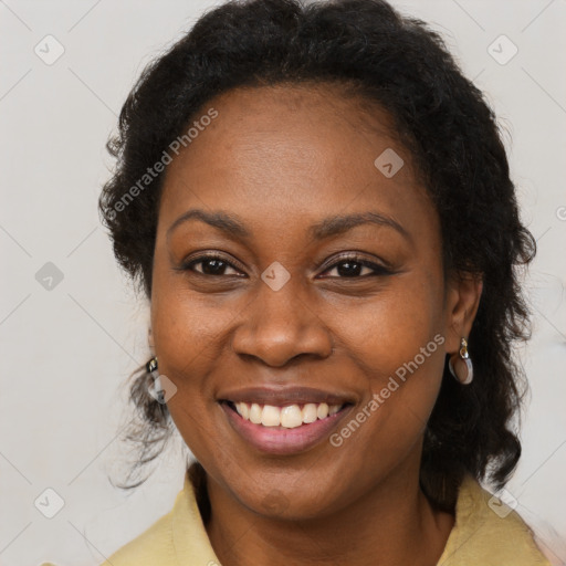 Joyful black adult female with long  brown hair and brown eyes