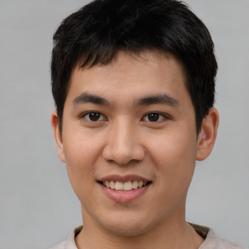Joyful asian young-adult male with short  brown hair and brown eyes