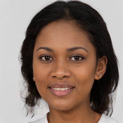 Joyful black young-adult female with long  brown hair and brown eyes