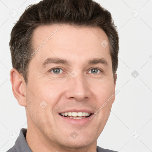 Joyful white young-adult male with short  brown hair and grey eyes