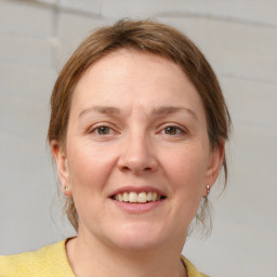 Joyful white young-adult female with medium  brown hair and blue eyes