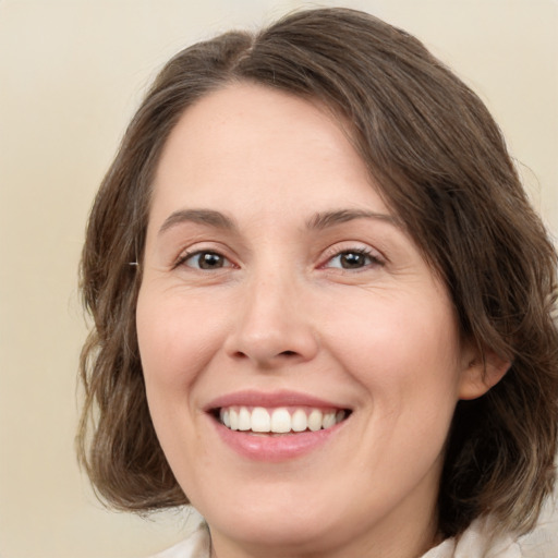 Joyful white young-adult female with medium  brown hair and green eyes