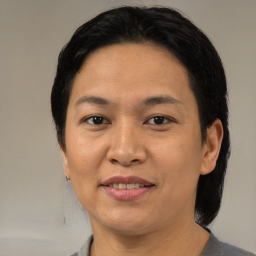 Joyful asian adult female with medium  brown hair and brown eyes