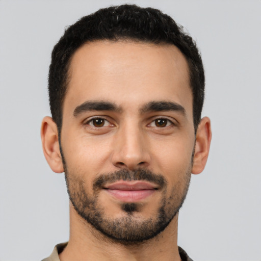 Joyful latino young-adult male with short  black hair and brown eyes