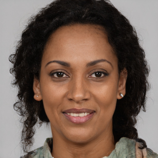 Joyful black adult female with medium  brown hair and brown eyes