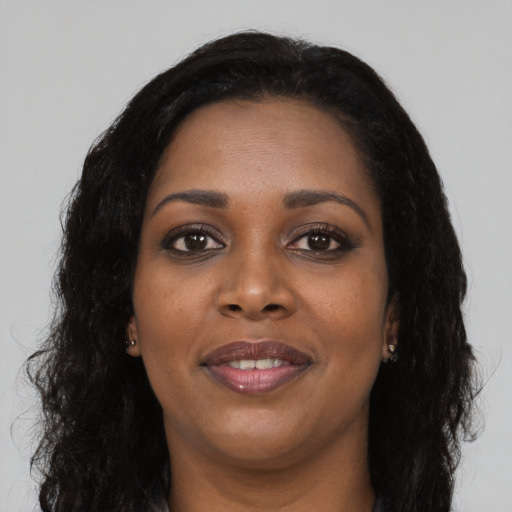 Joyful black young-adult female with long  black hair and brown eyes