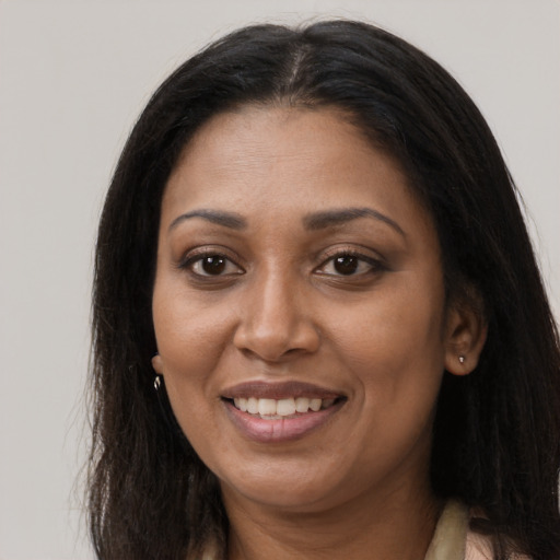 Joyful black young-adult female with long  brown hair and brown eyes