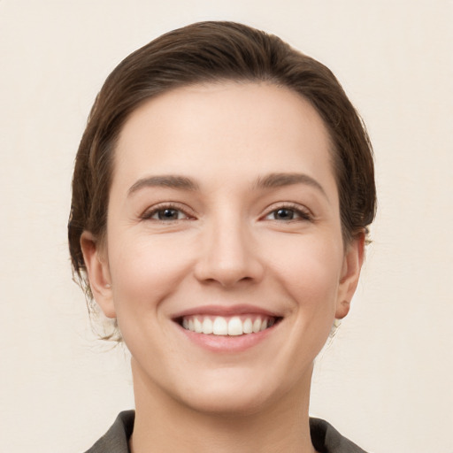 Joyful white young-adult female with short  brown hair and grey eyes