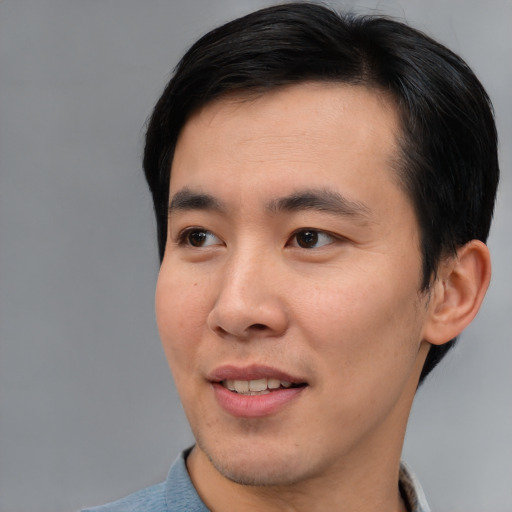Joyful asian young-adult male with short  brown hair and brown eyes