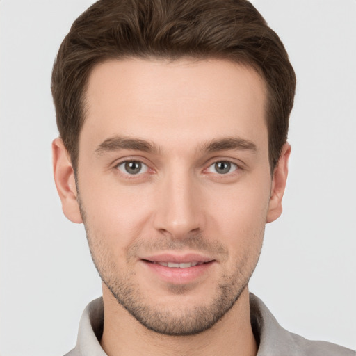 Joyful white young-adult male with short  brown hair and grey eyes