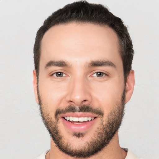 Joyful white young-adult male with short  black hair and brown eyes