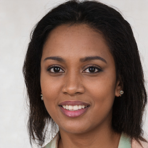 Joyful black young-adult female with long  brown hair and brown eyes