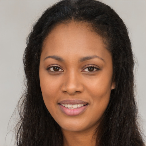 Joyful black young-adult female with long  brown hair and brown eyes