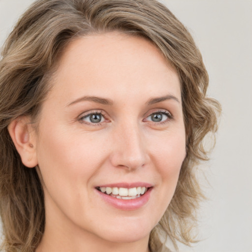 Joyful white young-adult female with medium  brown hair and green eyes