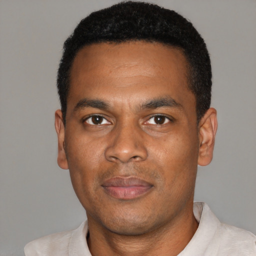 Joyful black young-adult male with short  black hair and brown eyes