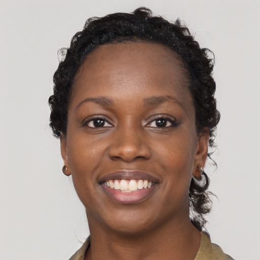 Joyful black young-adult female with long  black hair and brown eyes