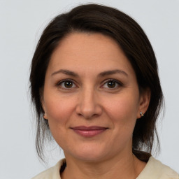 Joyful white adult female with medium  brown hair and brown eyes