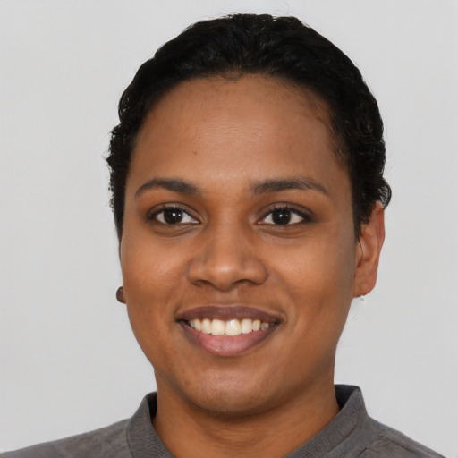 Joyful black young-adult female with short  black hair and brown eyes