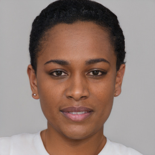Joyful black young-adult female with short  black hair and brown eyes