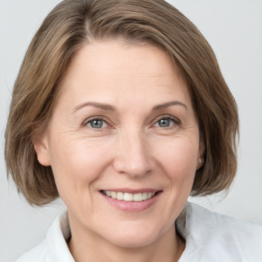 Joyful white adult female with medium  brown hair and grey eyes