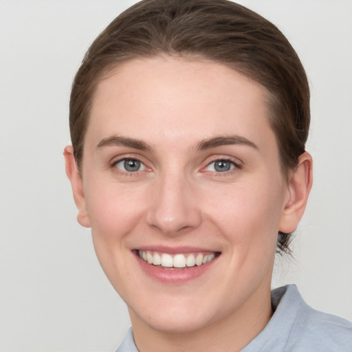 Joyful white young-adult female with short  brown hair and grey eyes