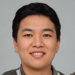 Joyful asian young-adult male with short  black hair and brown eyes