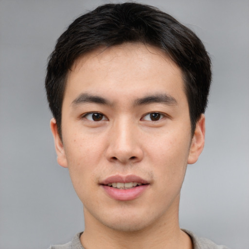Joyful asian young-adult male with short  brown hair and brown eyes
