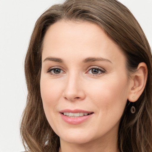 Joyful white young-adult female with long  brown hair and grey eyes