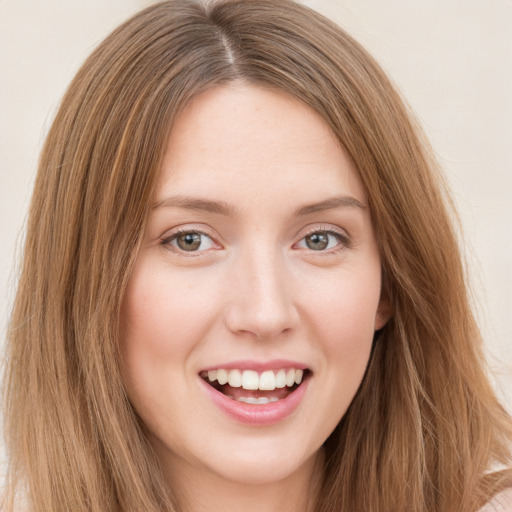 Joyful white young-adult female with long  brown hair and green eyes