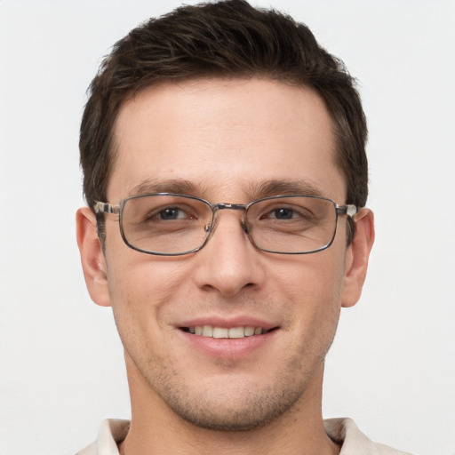 Joyful white young-adult male with short  brown hair and grey eyes