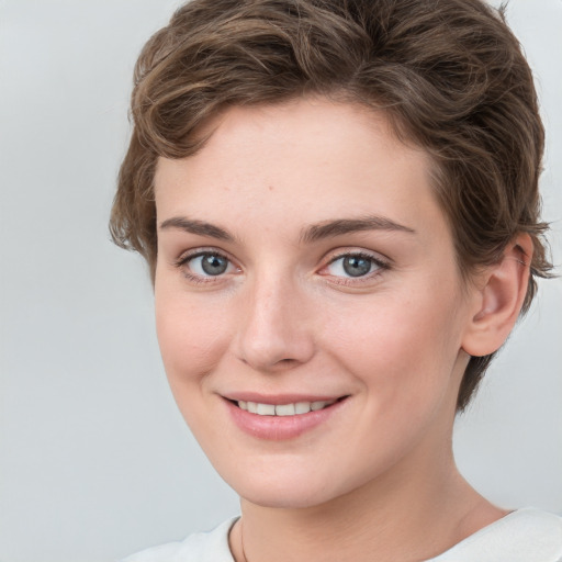 Joyful white young-adult female with short  brown hair and grey eyes